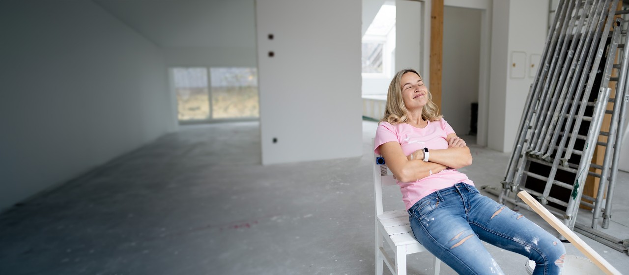 Frau sitzt auf einem Stuhl inmitten einer Baustelle